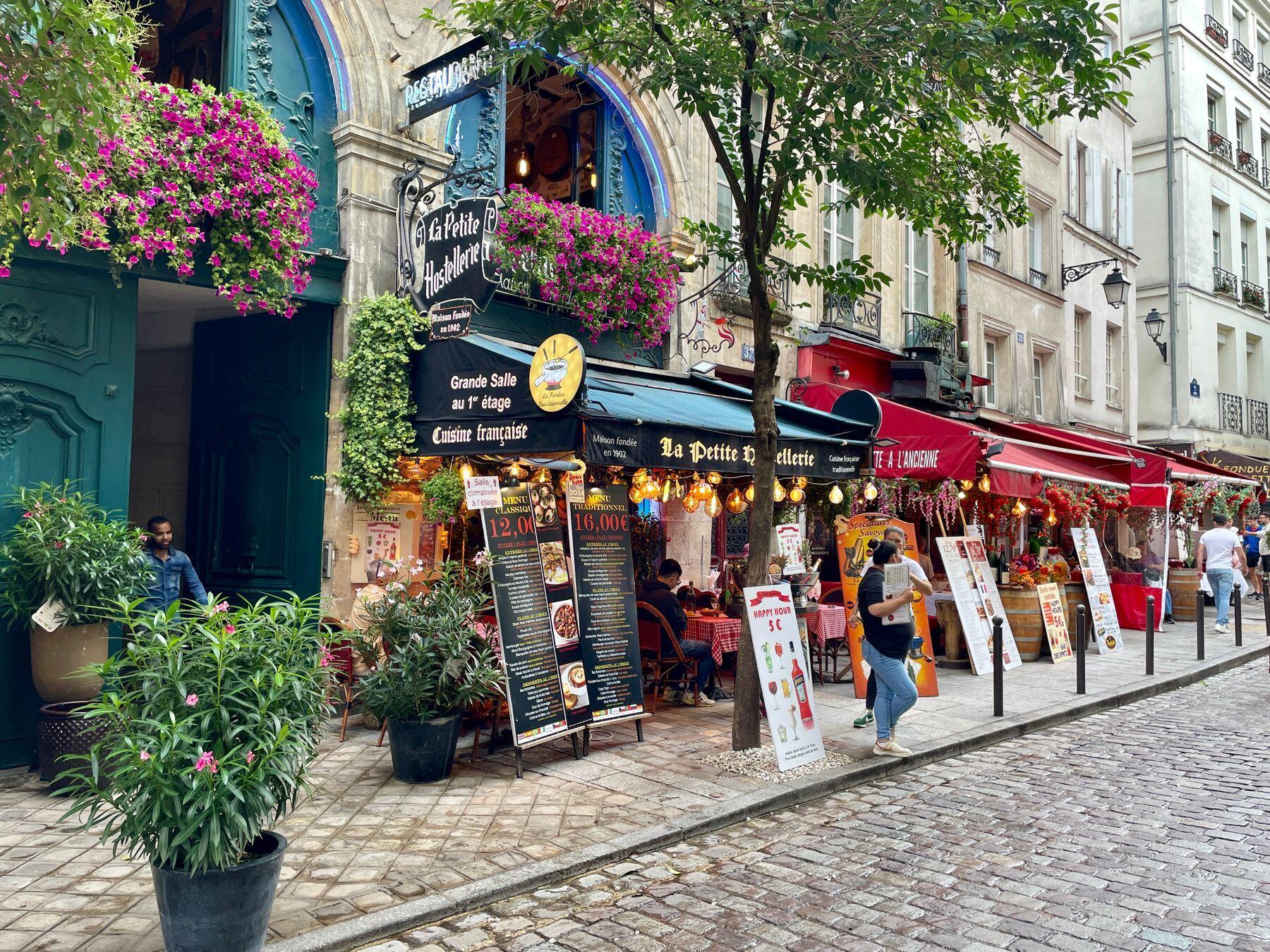 A Paris street of cafés, flower boxes and awnings, in sharp focus