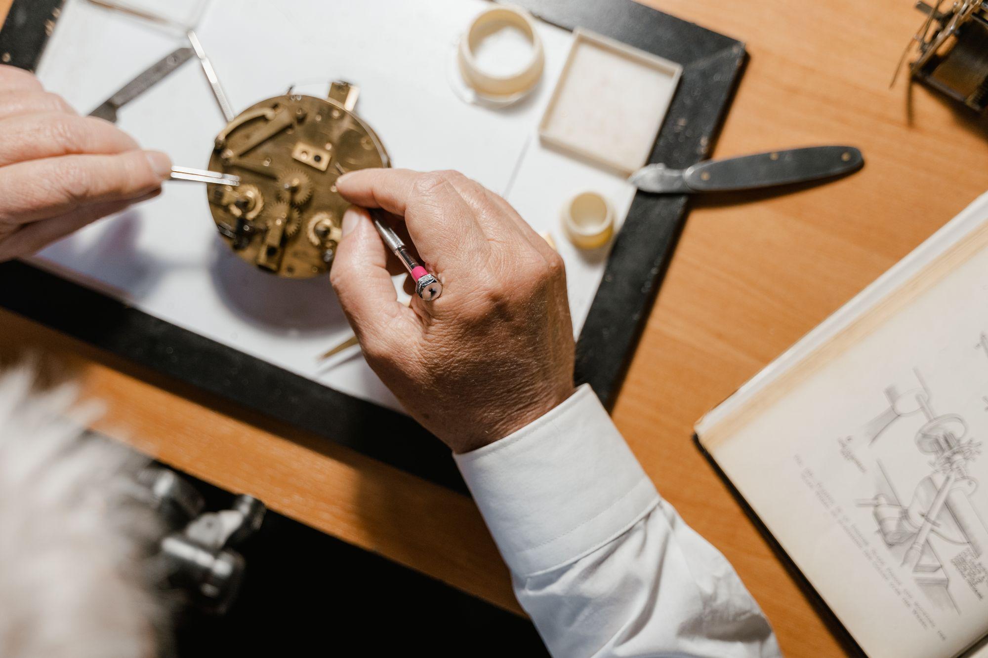A watchmaker assembling a movement at the bench